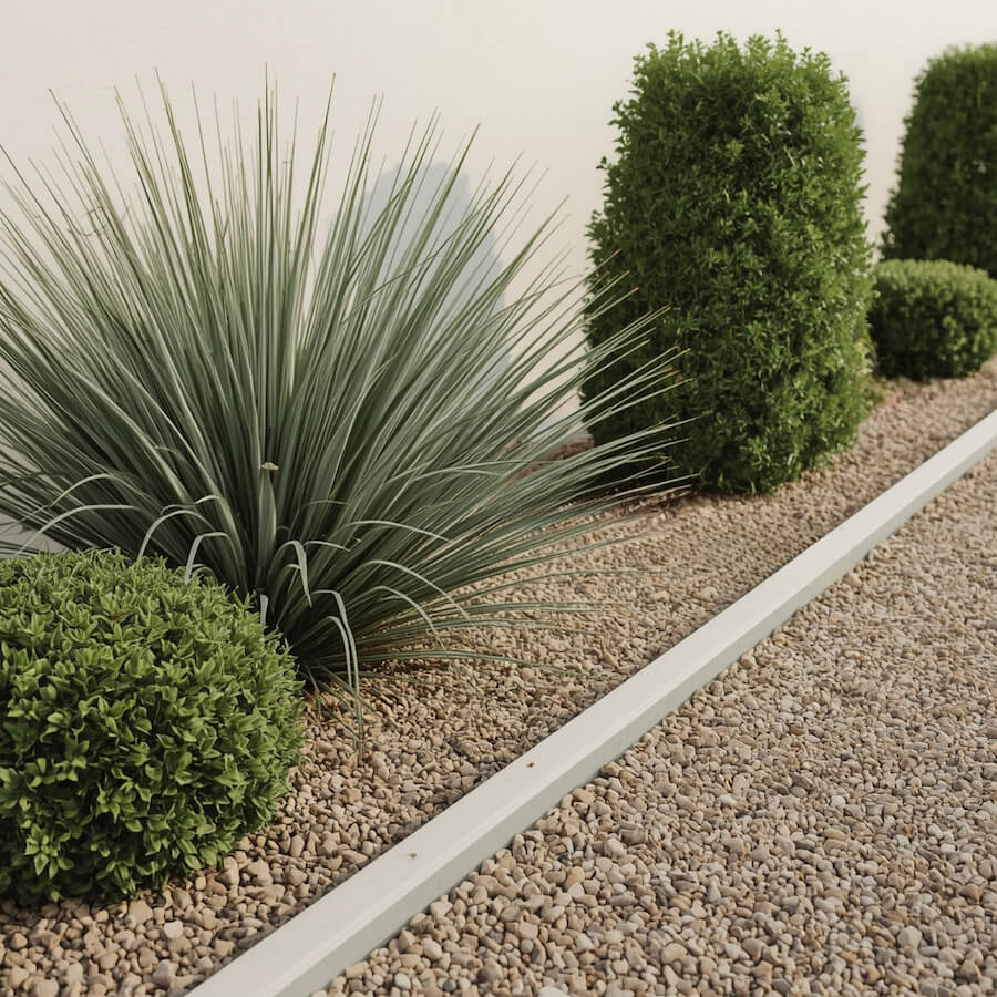 Minimalistyczna rabata żwirowa z juką przy ścianie