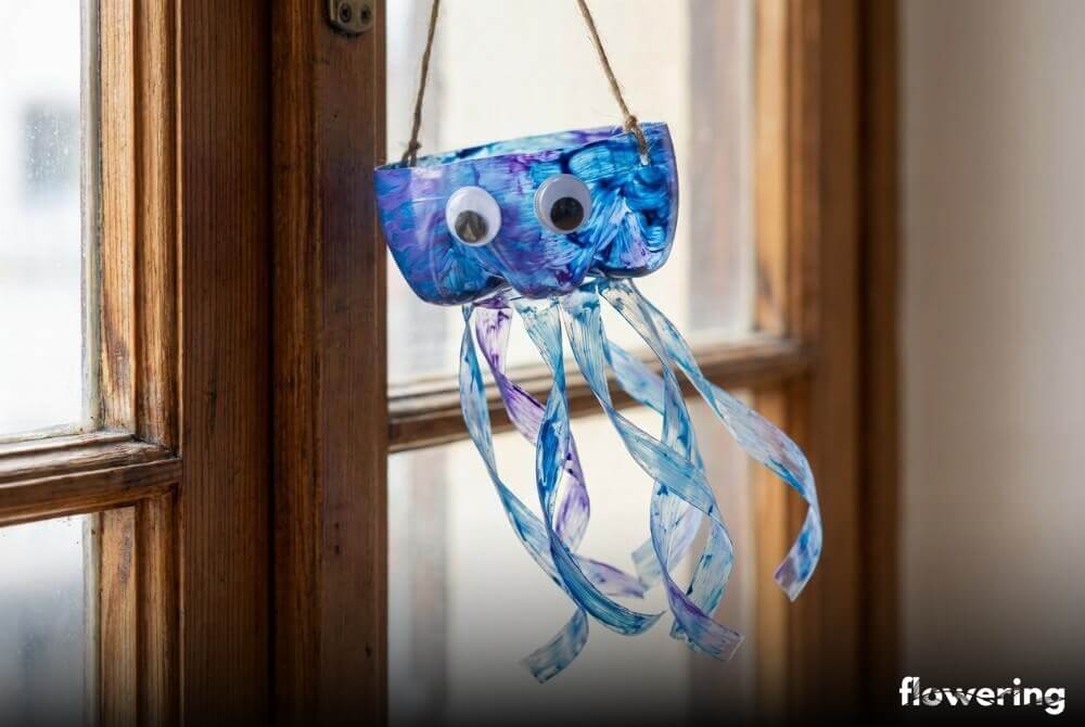 Meduza z plastikowej butelki z ponacinanymi mackami i doklejonymi oczami, zawieszona na sznurku przy oknie