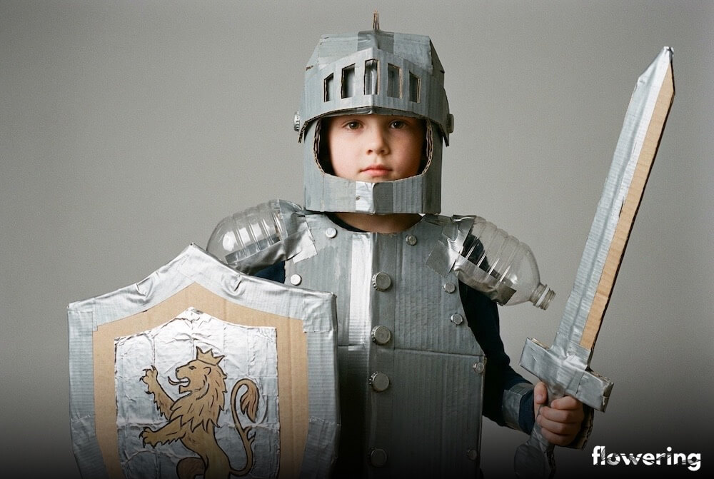 Dziecięcy strój rycerza z tektury z kartonowym hełmem oraz elementami z przeciętych plastikowych butelek, w zbliżeniu