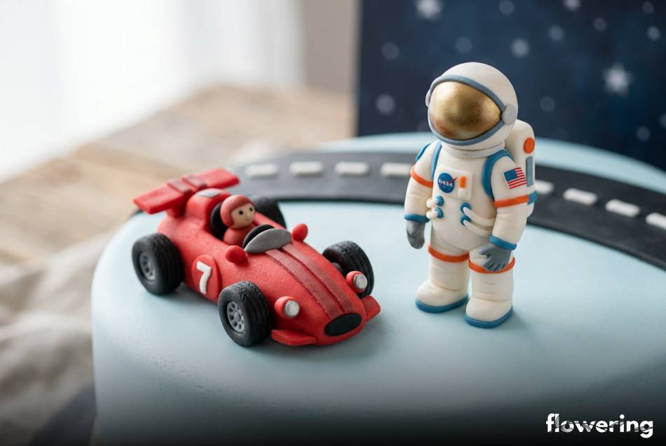 Ręcznie modelowane figurki z marcepanu i masy cukrowej na niebieskim torcie