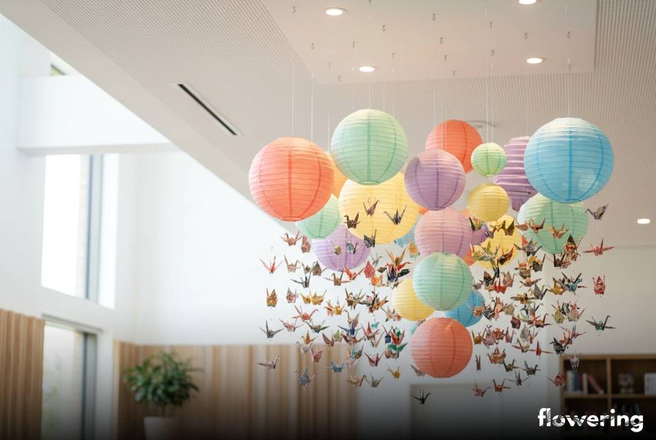 Kolorowa dekoracja sufitowa z papierowych lampionów i żurawi origami