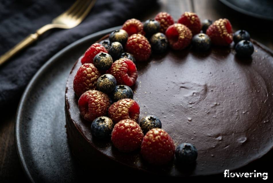 Maliny i borówki ze złotym pyłkiem na ciemnym ganache
