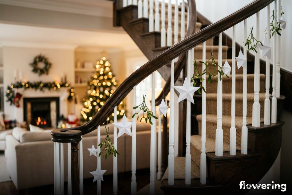 Papierowe gwiazdy origami i jemioła na balustradzie schodów