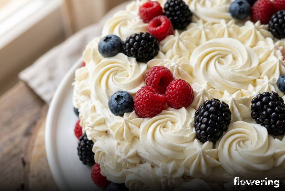 Klasyczne rozetki z bitej śmietany i świeże owoce leśne na torcie