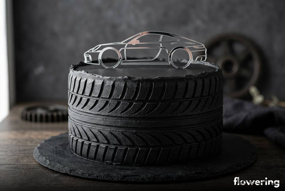 Czarny tort z teksturą opony i srebrnym geometrycznym topperem