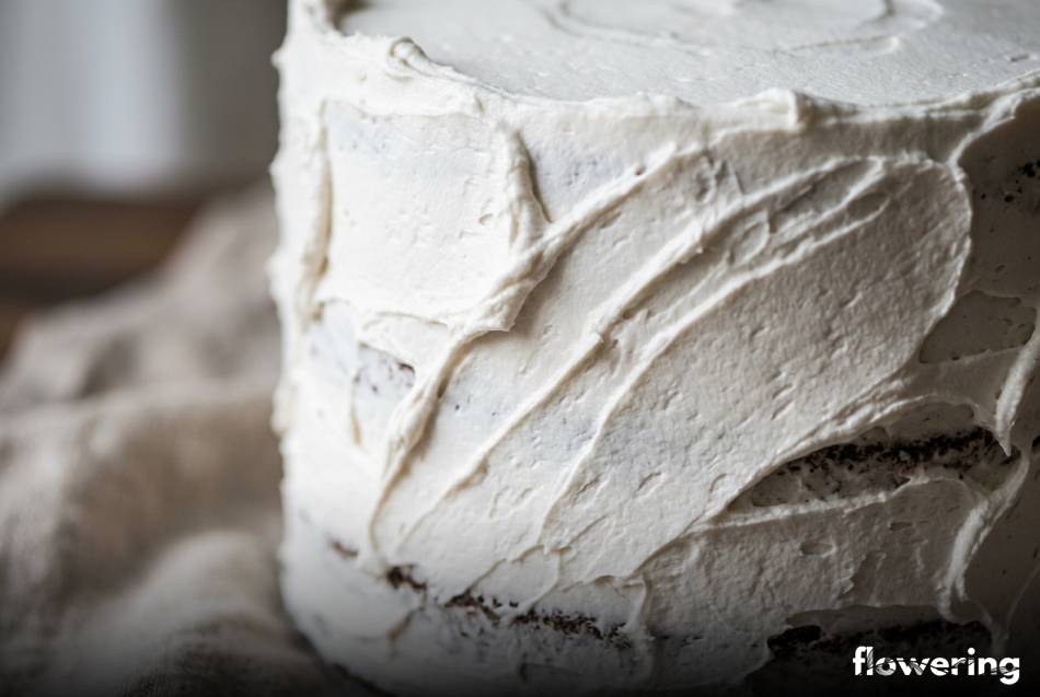 Biały wegański krem z aquafaby na torcie z rustykalną teksturą